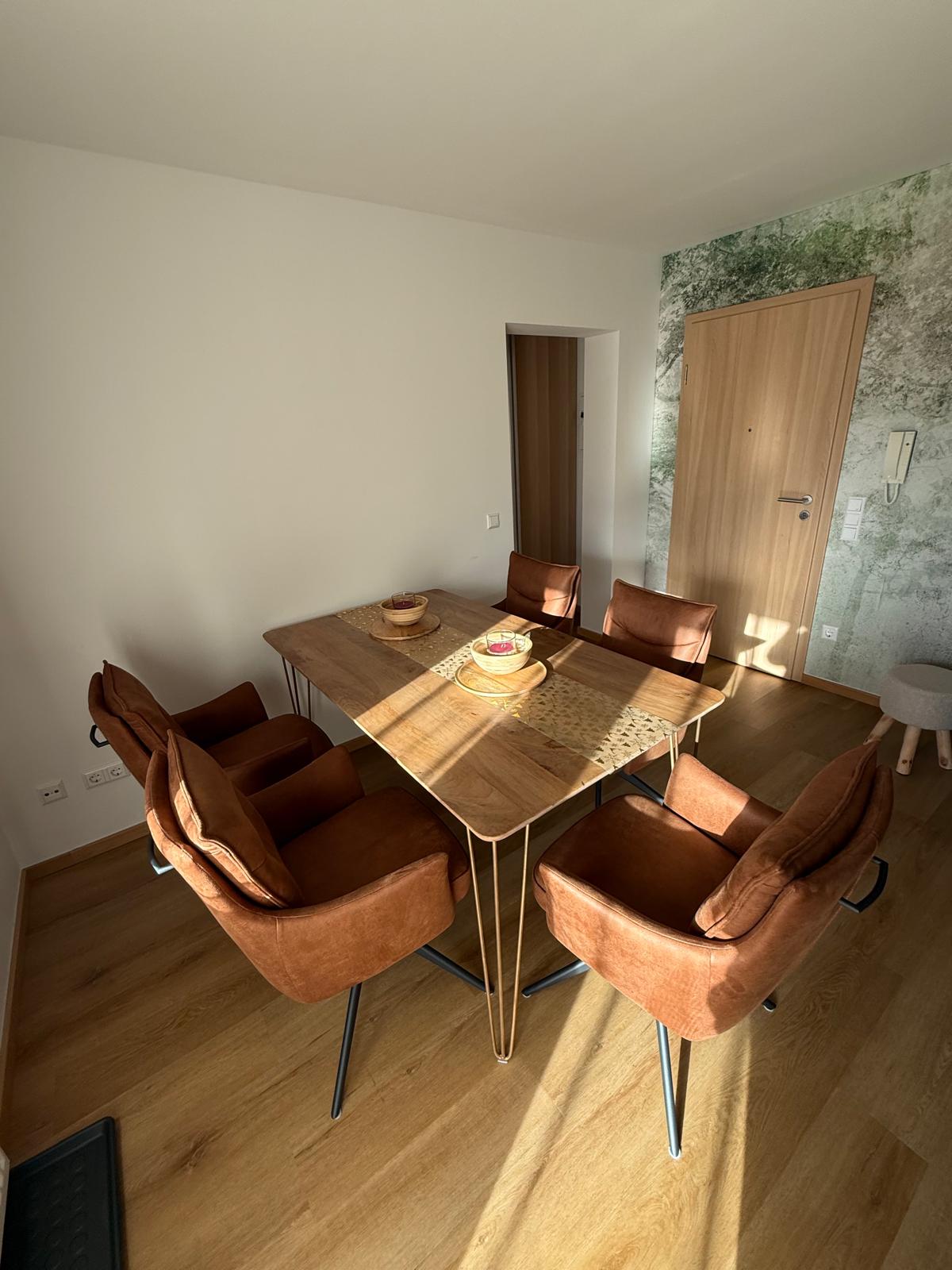 Esszimmer mit Holztisch und grüner Wandgestaltung